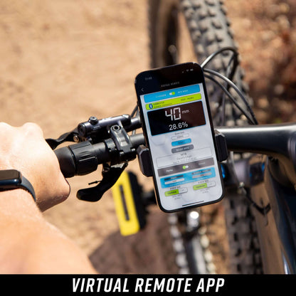 Person holding a smartphone using slacker app on a bike, showing suspension setting and other metrics.